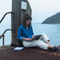 Freya Johns sat on a pier writing on her laptop.